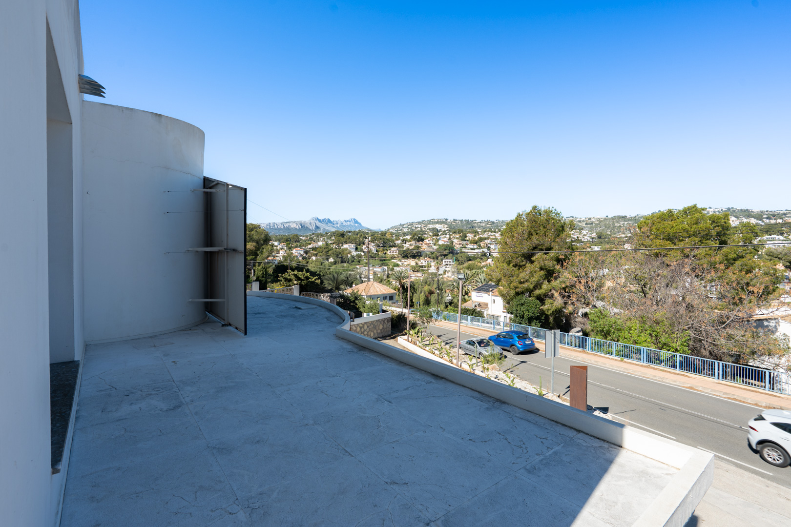 Spacious terrace featuring light-colored tiling and panoramic views of the Sierra de Bernia mountains and the surrounding valley.