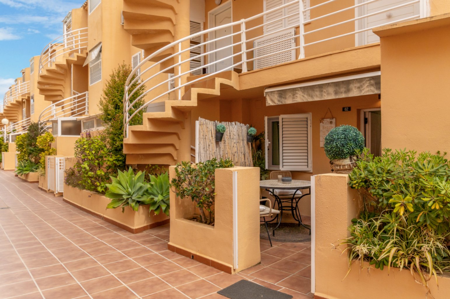 Exterior view of the private terrace with bistro table and access to the spiral staircase.