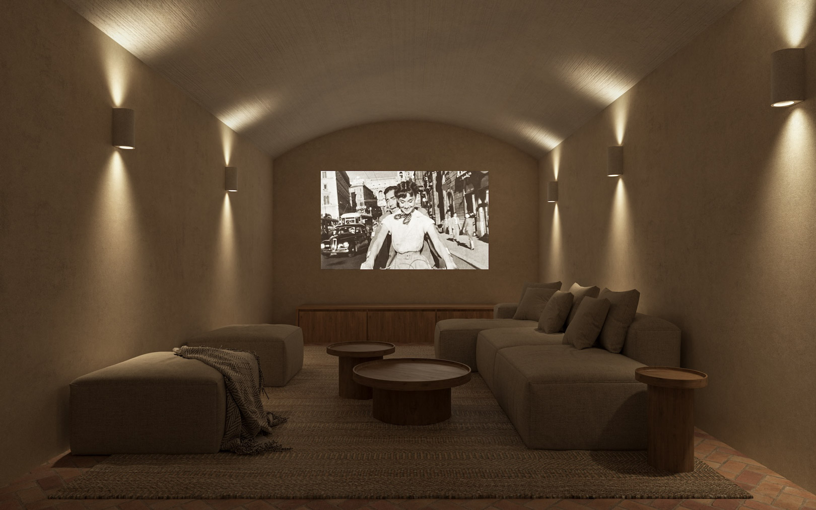 Private cinema room featuring a vaulted ceiling, textured plaster walls, and warm wall sconces. Includes modular seating, wooden tables, and traditional terracotta flooring.