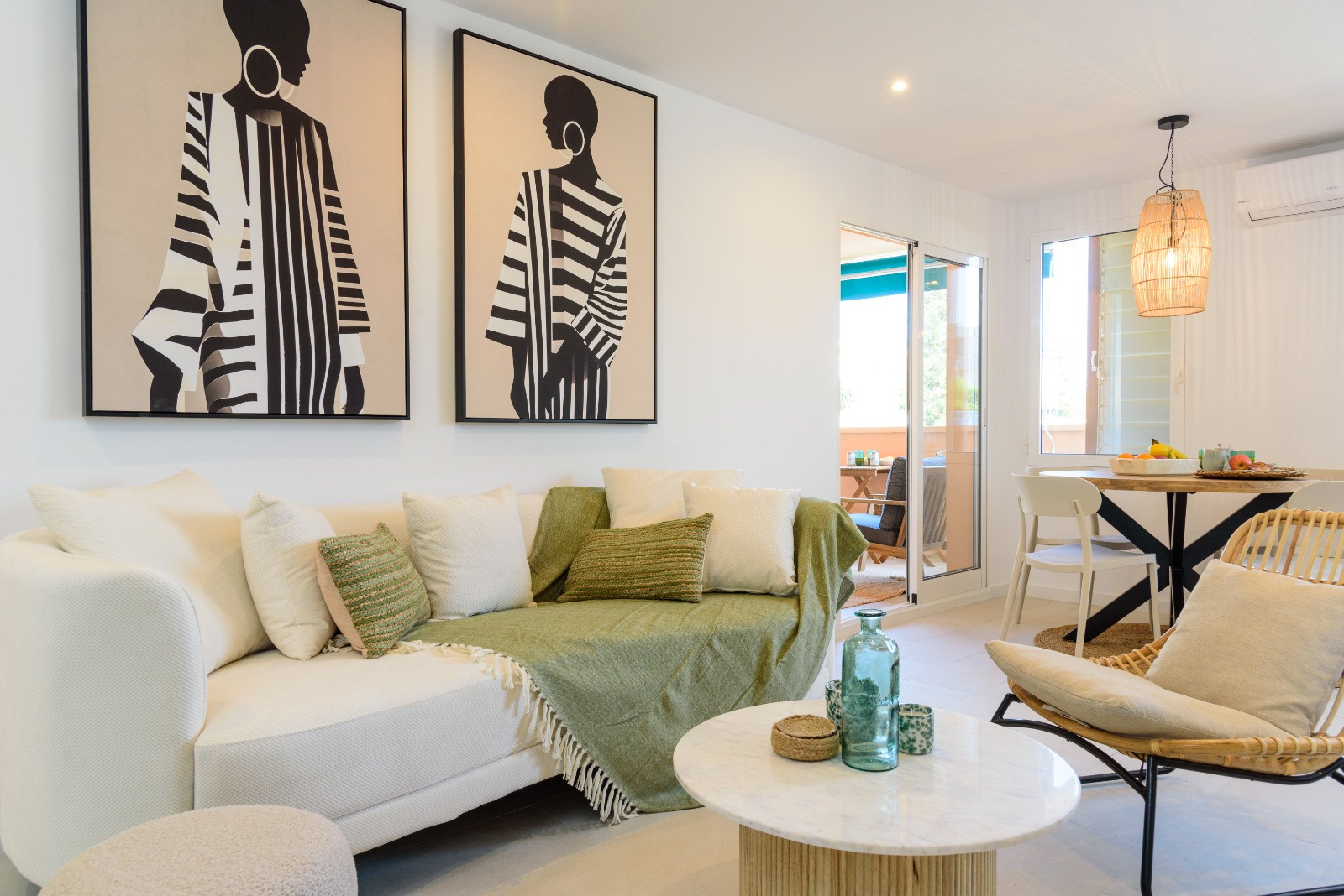 Contemporary living area featuring large-scale art, a marble coffee table, and neutral seating. Large glass doors provide direct access to the private terrace.
