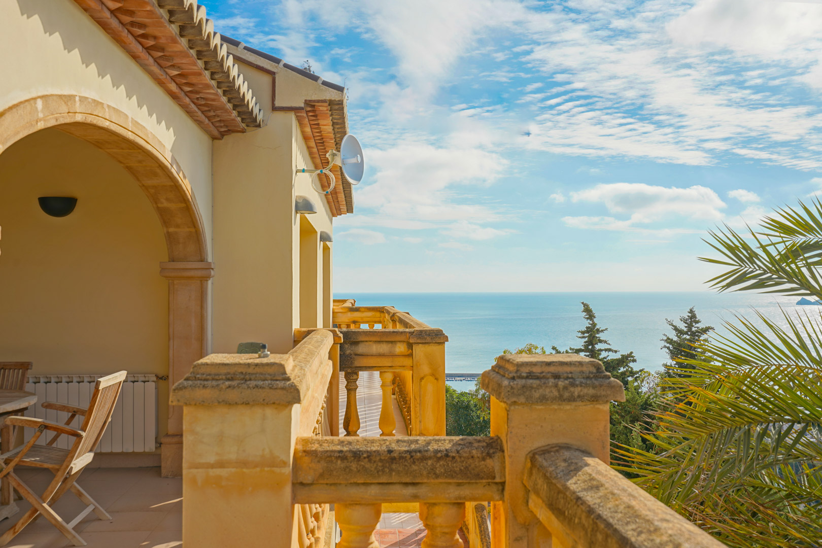 Upper terrace featuring traditional stone balustrades and arched architecture, providing panoramic Mediterranean Sea views and a clear coastal horizon.