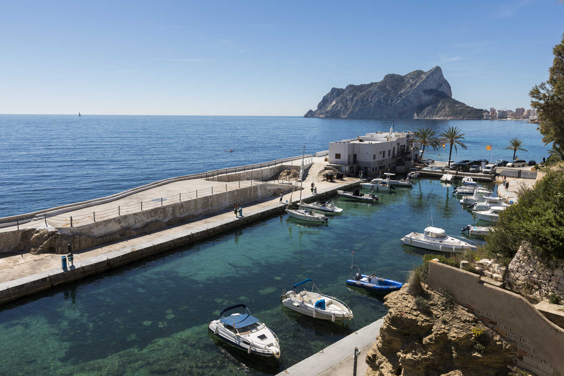 Panoramic view of the nearby marina featuring the Peñón de Ifach in the background, showcasing the crystal-clear waters and the villa's proximity to the Mediterranean coast.