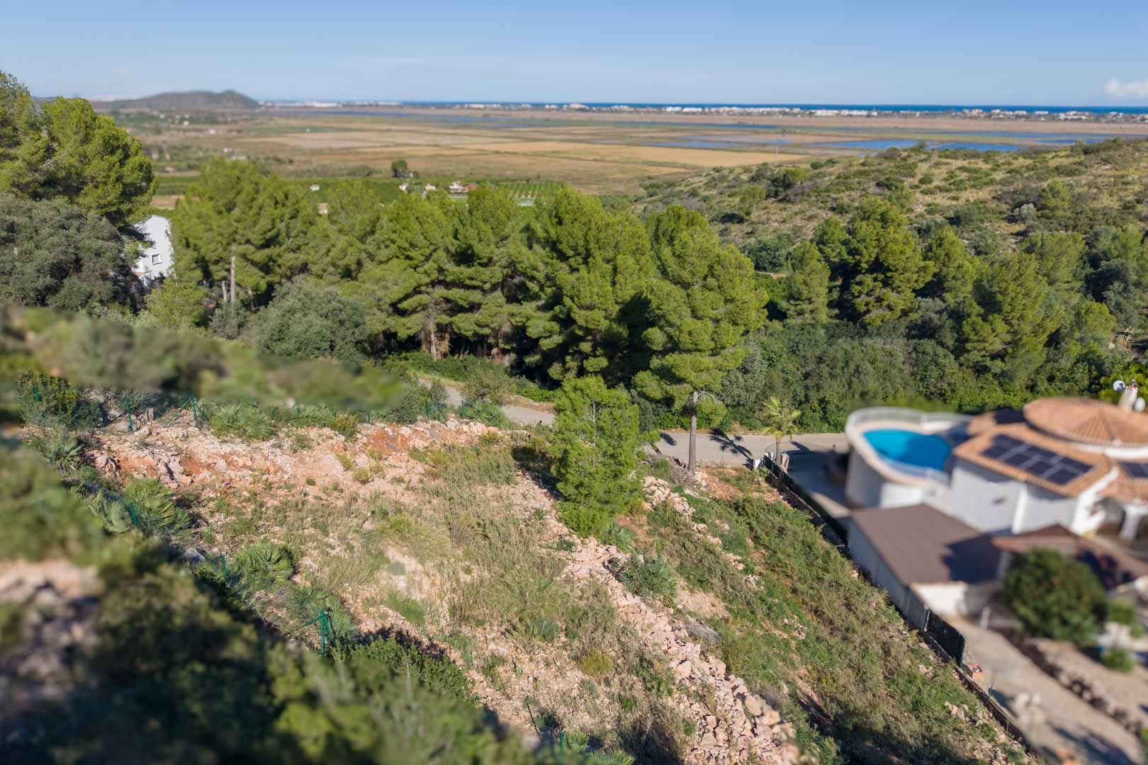 Elevated plot featuring perimeter fencing and panoramic views overlooking the Marjal de Pego Natural Park and the coastline.