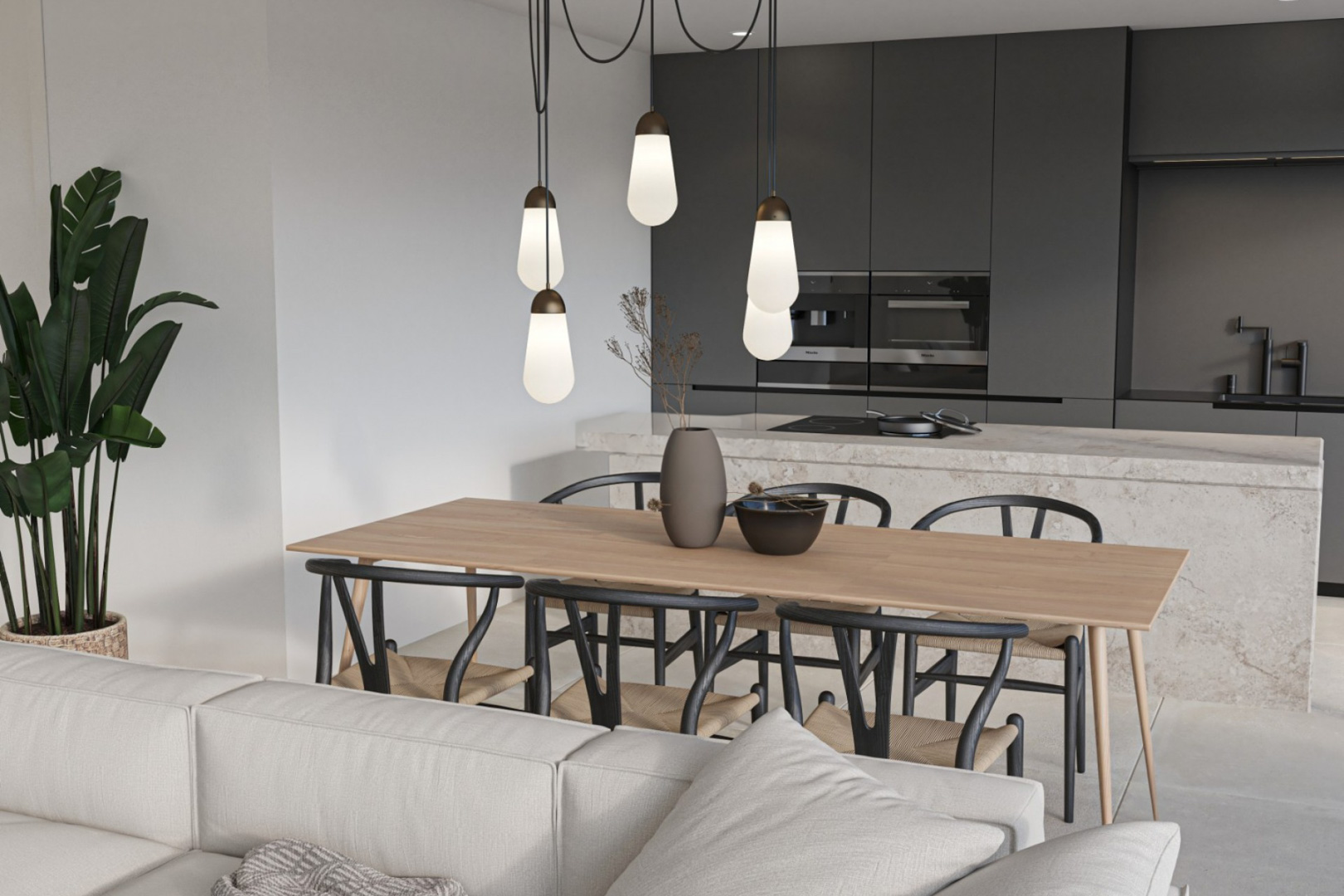 Modern dining area and kitchen featuring a natural stone island, anthracite cabinetry with integrated appliances, and designer pendant lighting over a wooden table.