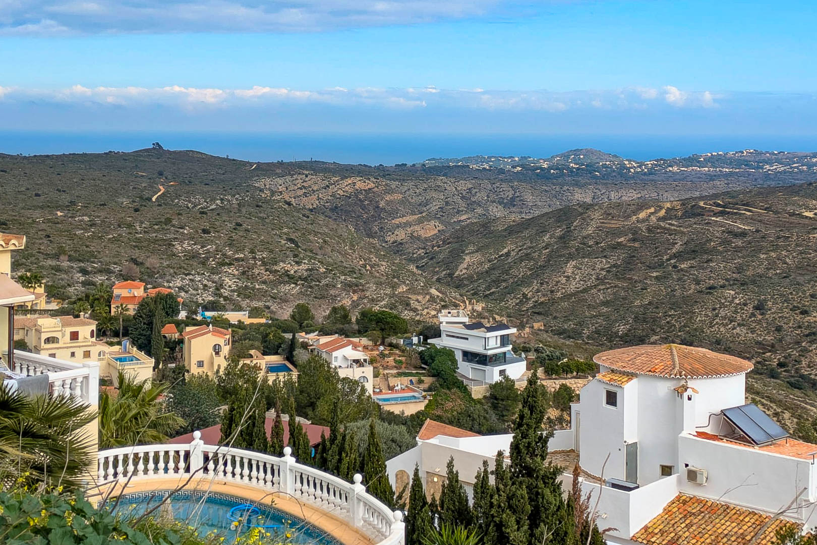 Panoramic view from Cumbre del Sol overlooking the Mediterranean Sea, featuring the rugged coastal landscape and hillside villas in Benitachell.
