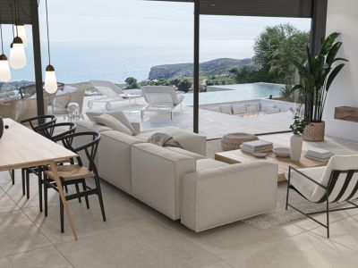 Bright living room with sea views, dining area with designer chairs, and access to a terrace with an infinity pool.