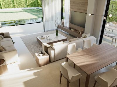 View of the living-dining area with upholstered sofas, a wooden dining table, and access to the garden with a pool.