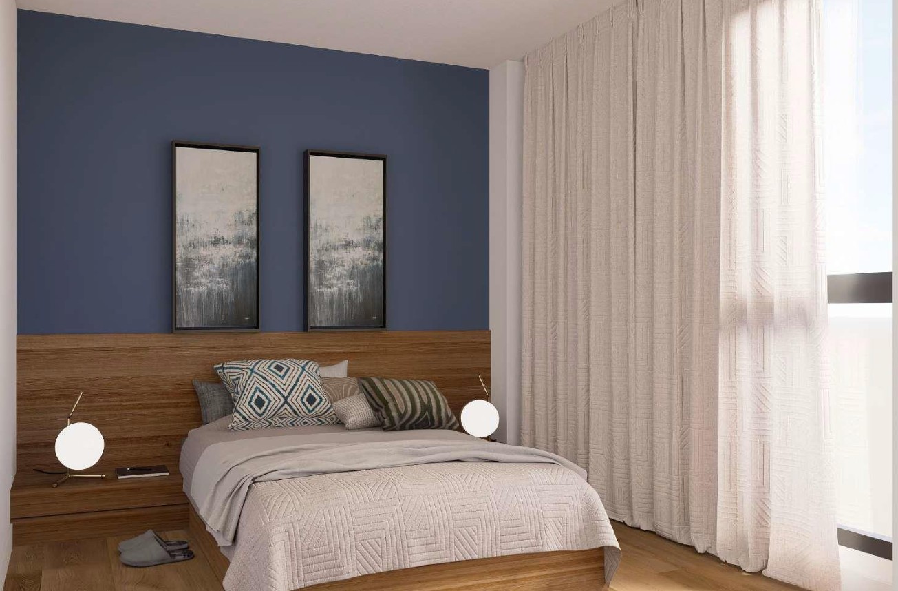 Contemporary bedroom featuring a blue accent wall, integrated wooden headboard with bedside lighting, and floor-to-ceiling textured curtains.