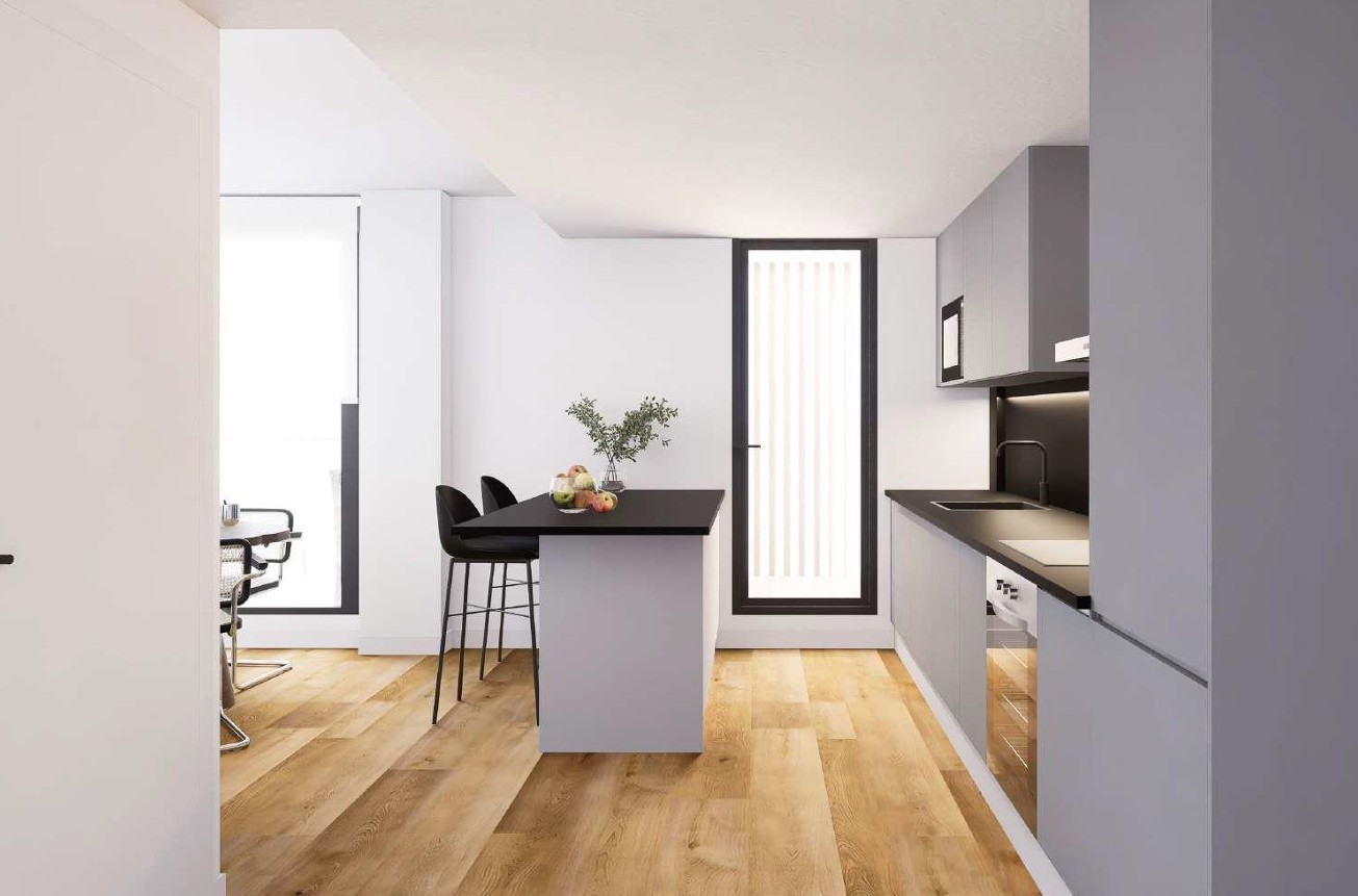 Contemporary kitchen featuring a central island with black countertops and bar stools. Includes minimalist grey cabinetry, integrated appliances, and light oak-effect flooring.