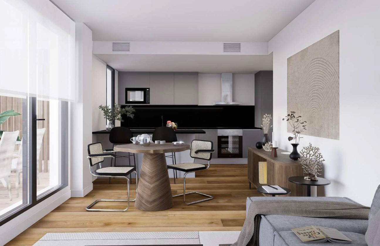 Open-plan living area featuring a contemporary grey kitchen, wood-effect flooring, and large glass doors opening onto a private Mediterranean terrace.