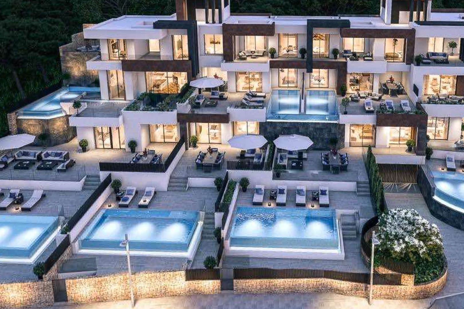 Exterior view of a modern residential complex featuring tiered terraces, private illuminated infinity pools, and a mix of stone and white architectural finishes.