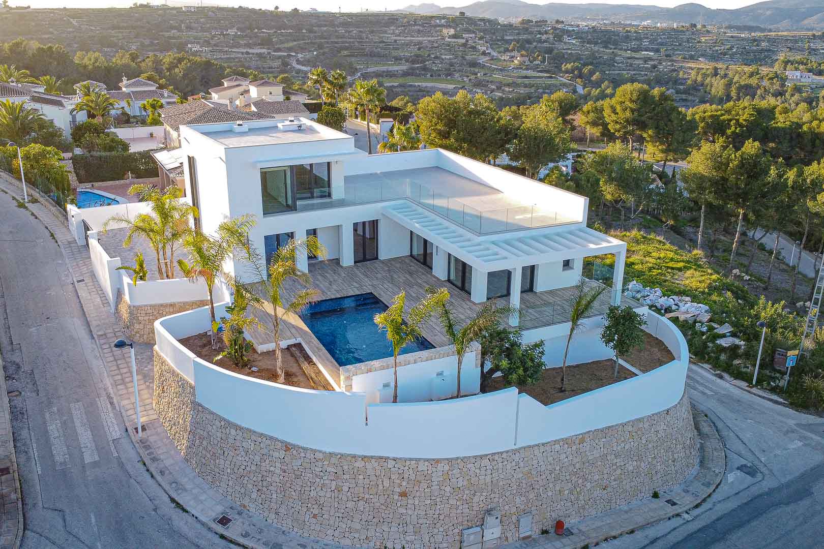 Aerial view of modern villa featuring pool, terraces, and Mediterranean garden in Benimeit, Moraira.