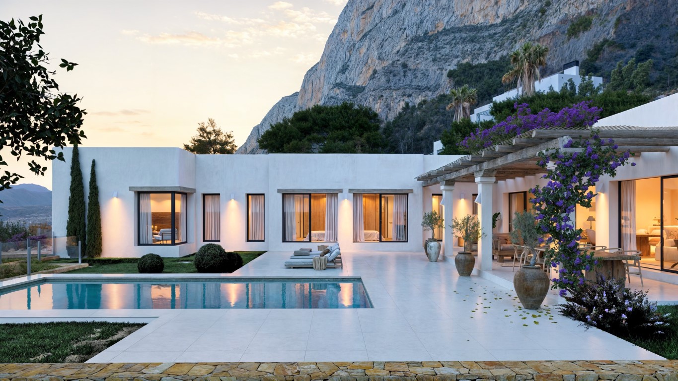 Exterior view featuring a private pool, white tiled terrace, and wooden pergola with bougainvillea, set against the dramatic backdrop of the Montgó mountain.