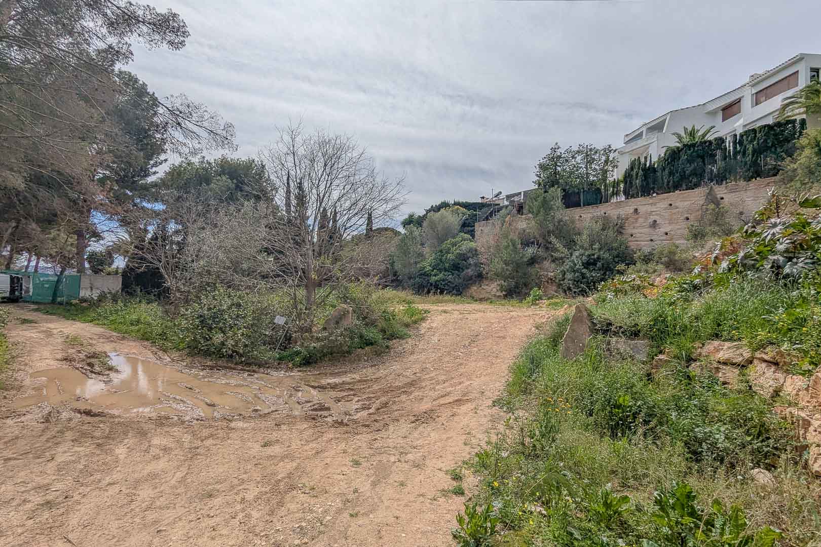 Elevated building plot in La Corona, showcasing the natural terrain surrounded by Mediterranean vegetation and existing hillside residences.