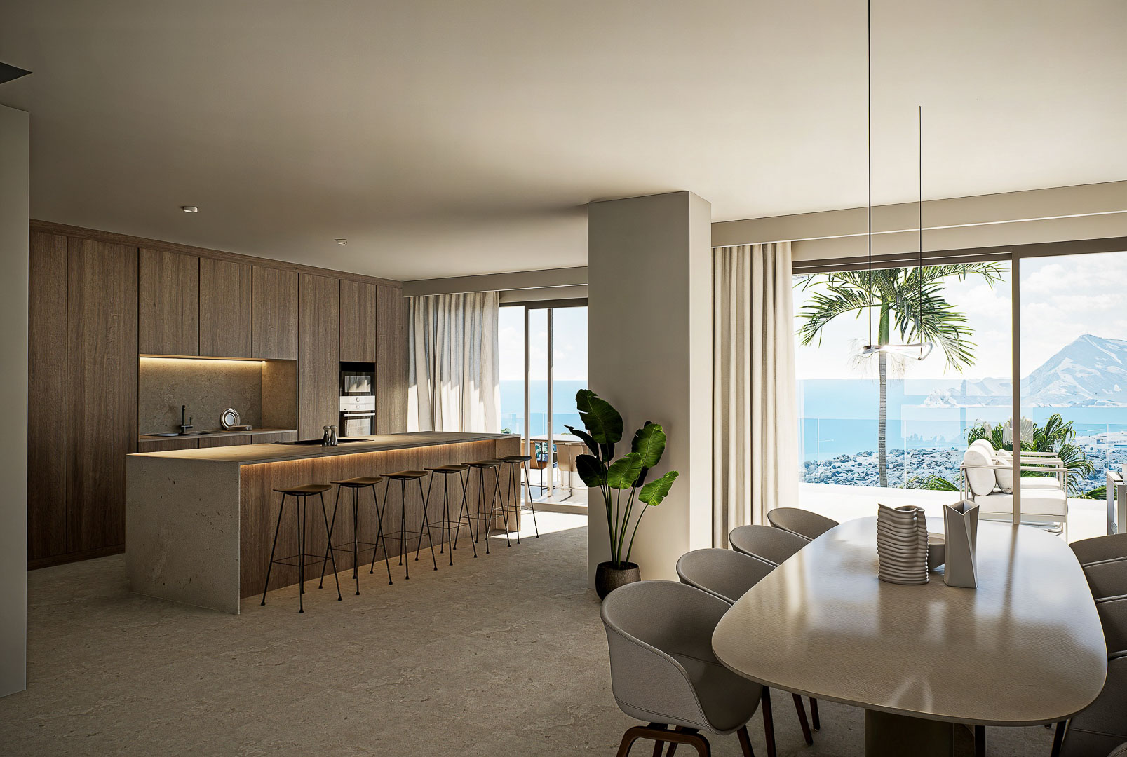 Designer kitchen featuring a stone island and integrated dining area, with floor-to-ceiling windows overlooking the Mediterranean Sea and coastline.