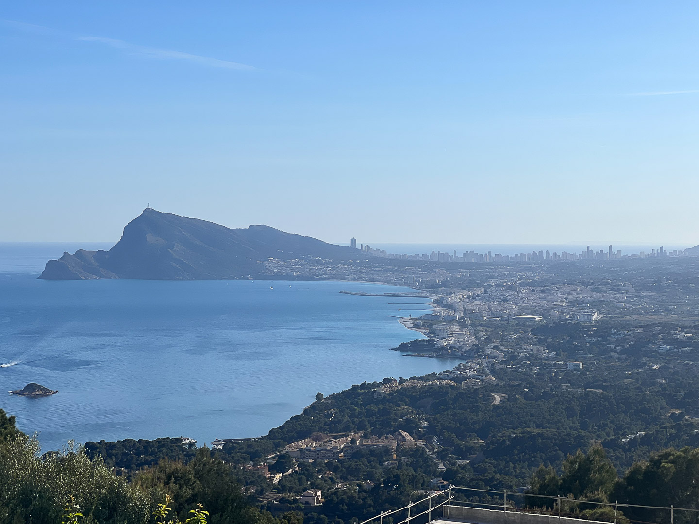 Panoramic views from Altea Hills overlooking the bay, featuring the Sierra Helada mountain and the distant Benidorm skyline across the Mediterranean.