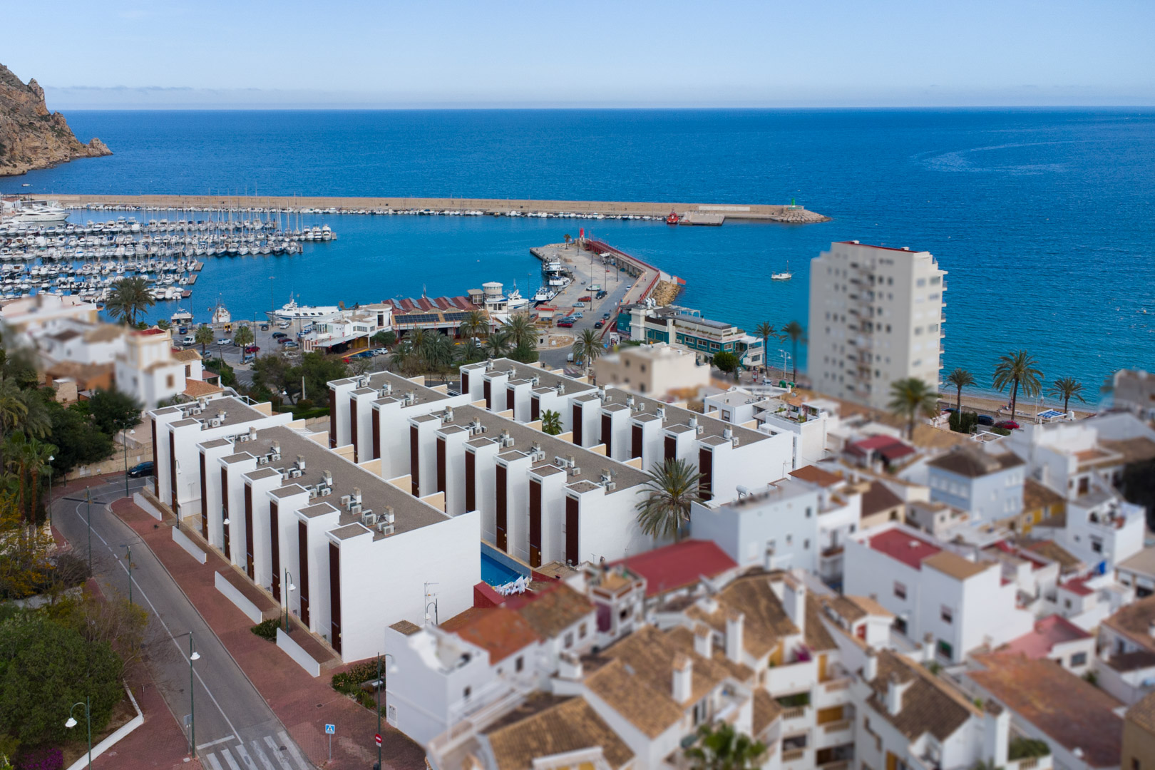 Aerial view of the Jávea port and modern residential complexes by the Mediterranean Sea, showcasing the property's prime coastal location.
