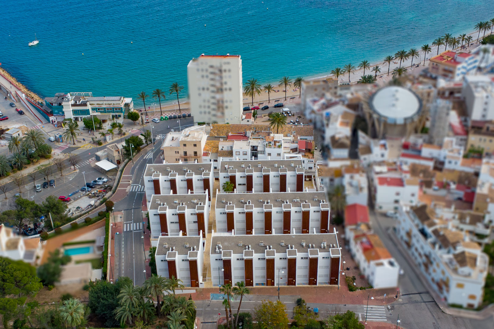Aerial view of the residential complex near Jávea Port, showcasing its modern architecture and immediate proximity to the Mediterranean Sea and promenade.