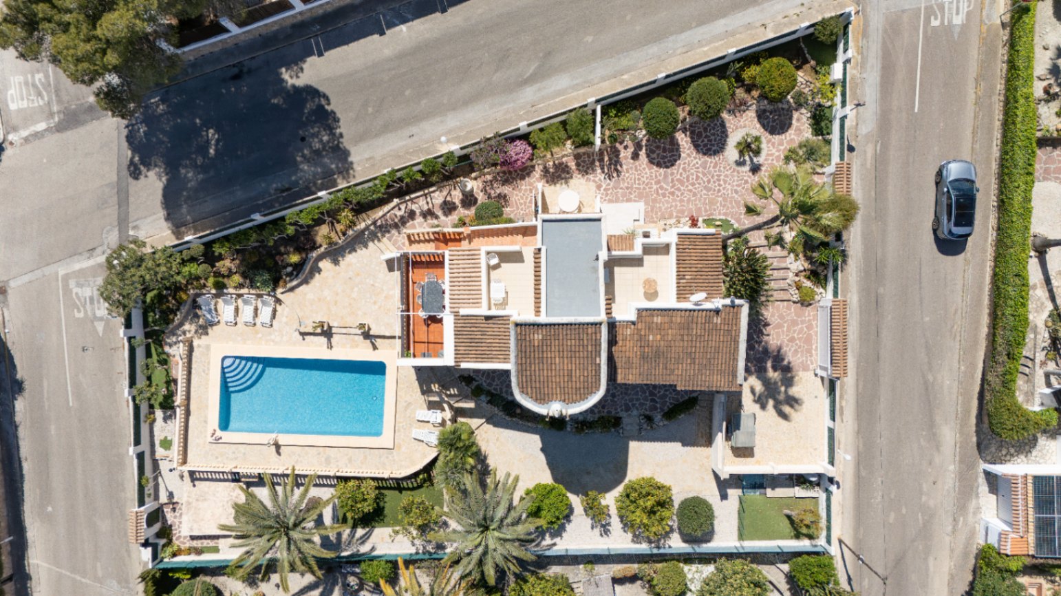 Overhead aerial view displaying the 1,030 m² corner plot, featuring the private swimming pool, landscaped Mediterranean gardens, and the villa's multi-level terrace layout.