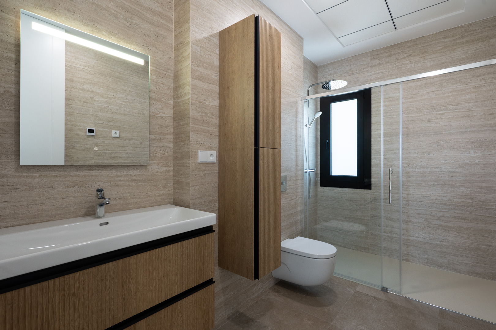Modern bathroom featuring textured porcelain wall tiles, floating wooden vanity, wall-hung toilet, and a walk-in shower with a glass partition.
