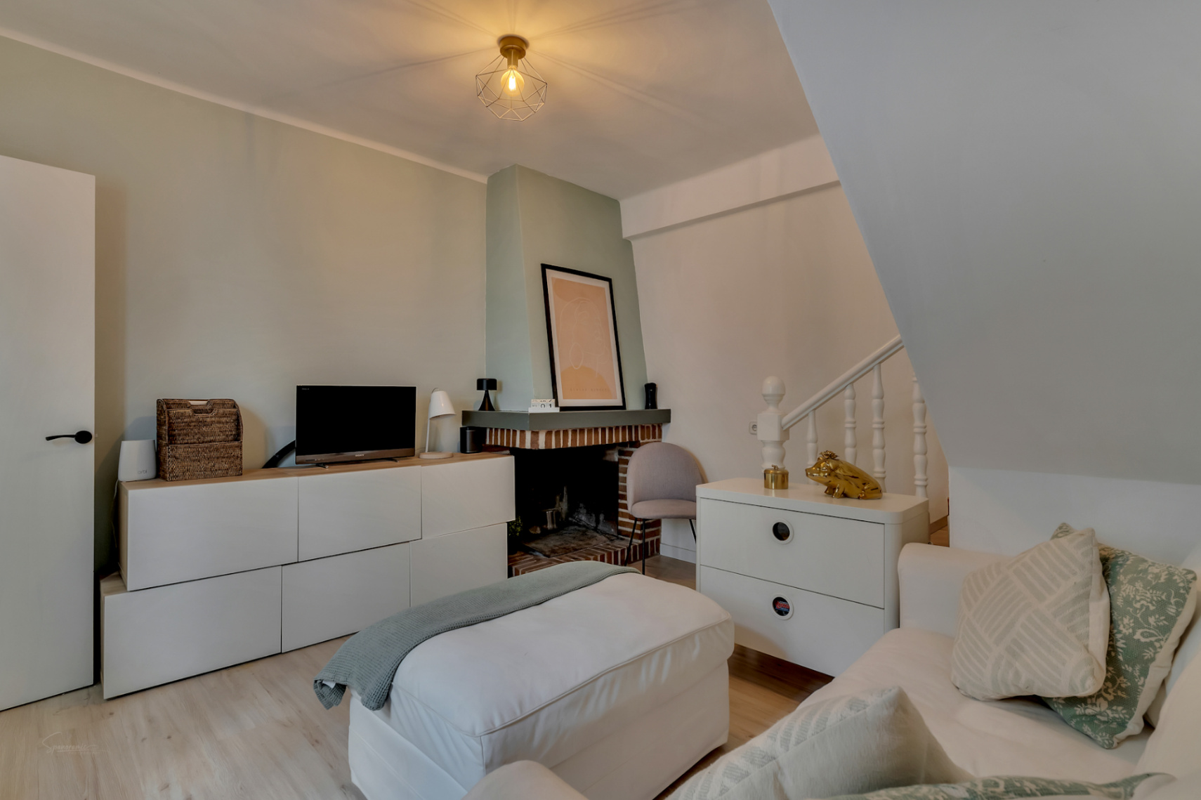 Bright living room featuring a brick fireplace, light wood floors, and modern furniture in neutral tones.