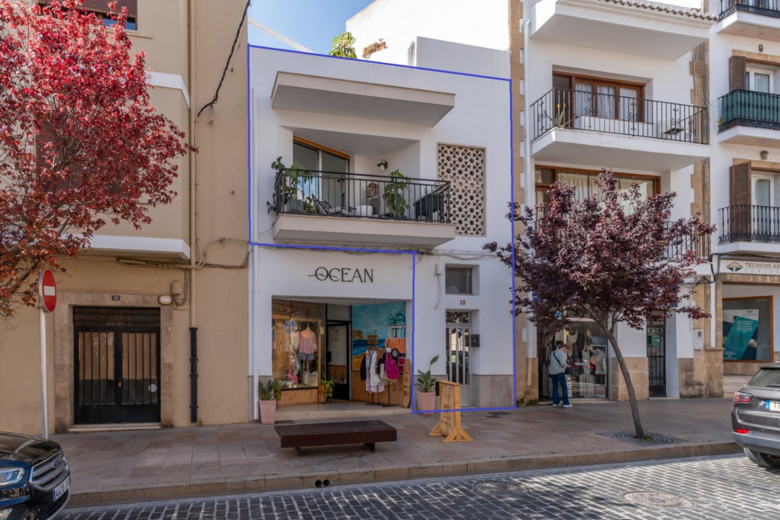 Facade of the renovated building featuring a balcony and 'Ocean' shop in Jávea's historic center.