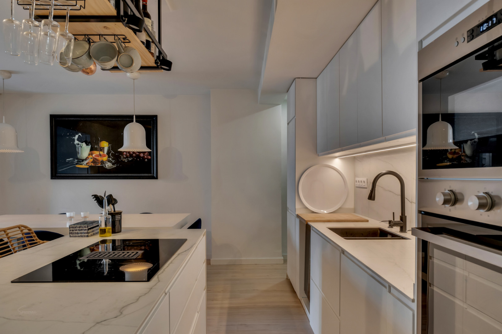 Kitchen detail with central island, marble countertops, and integrated appliances.