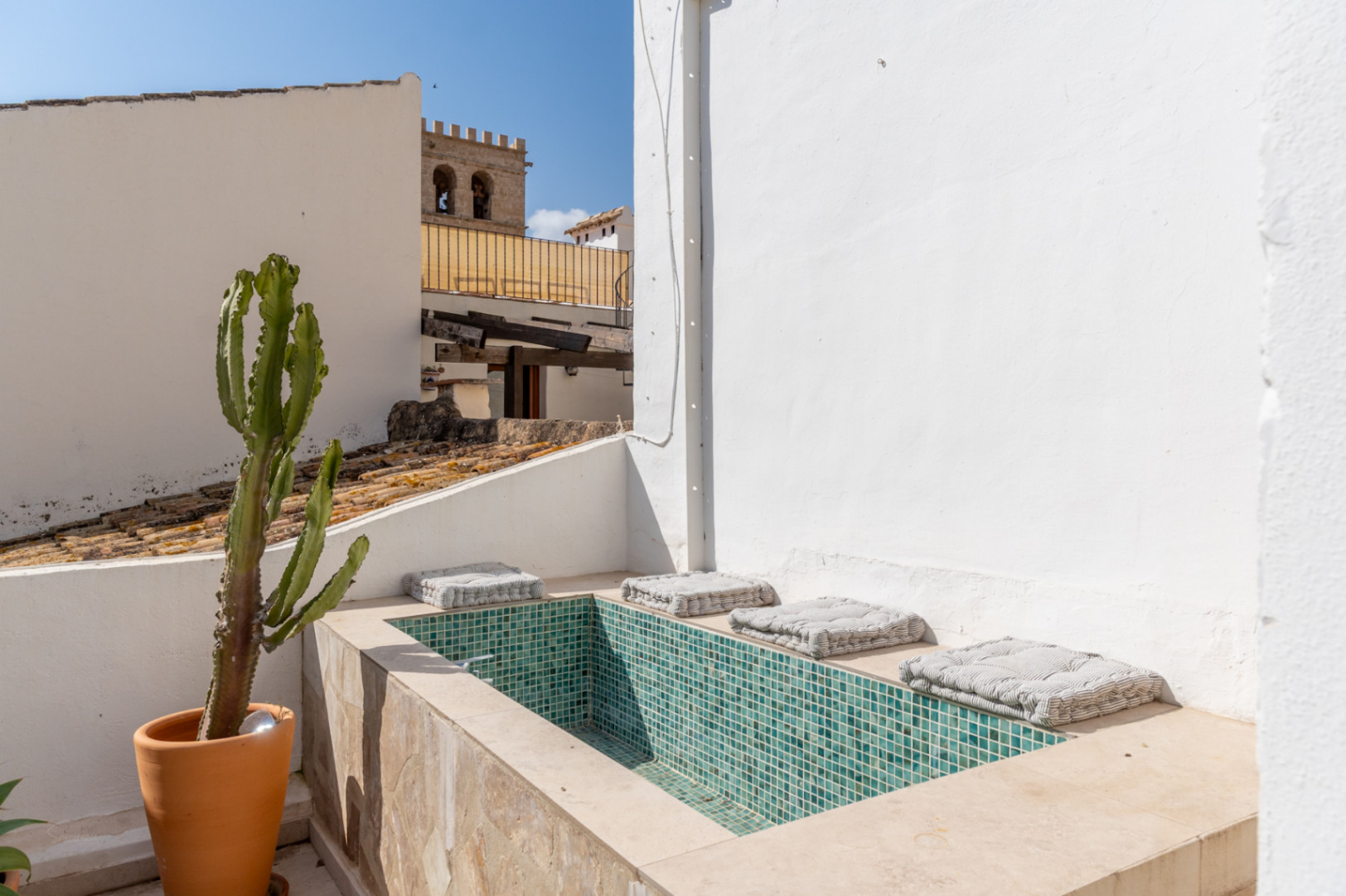 Terrace detail with turquoise mosaic pool and views of Jávea's old town.