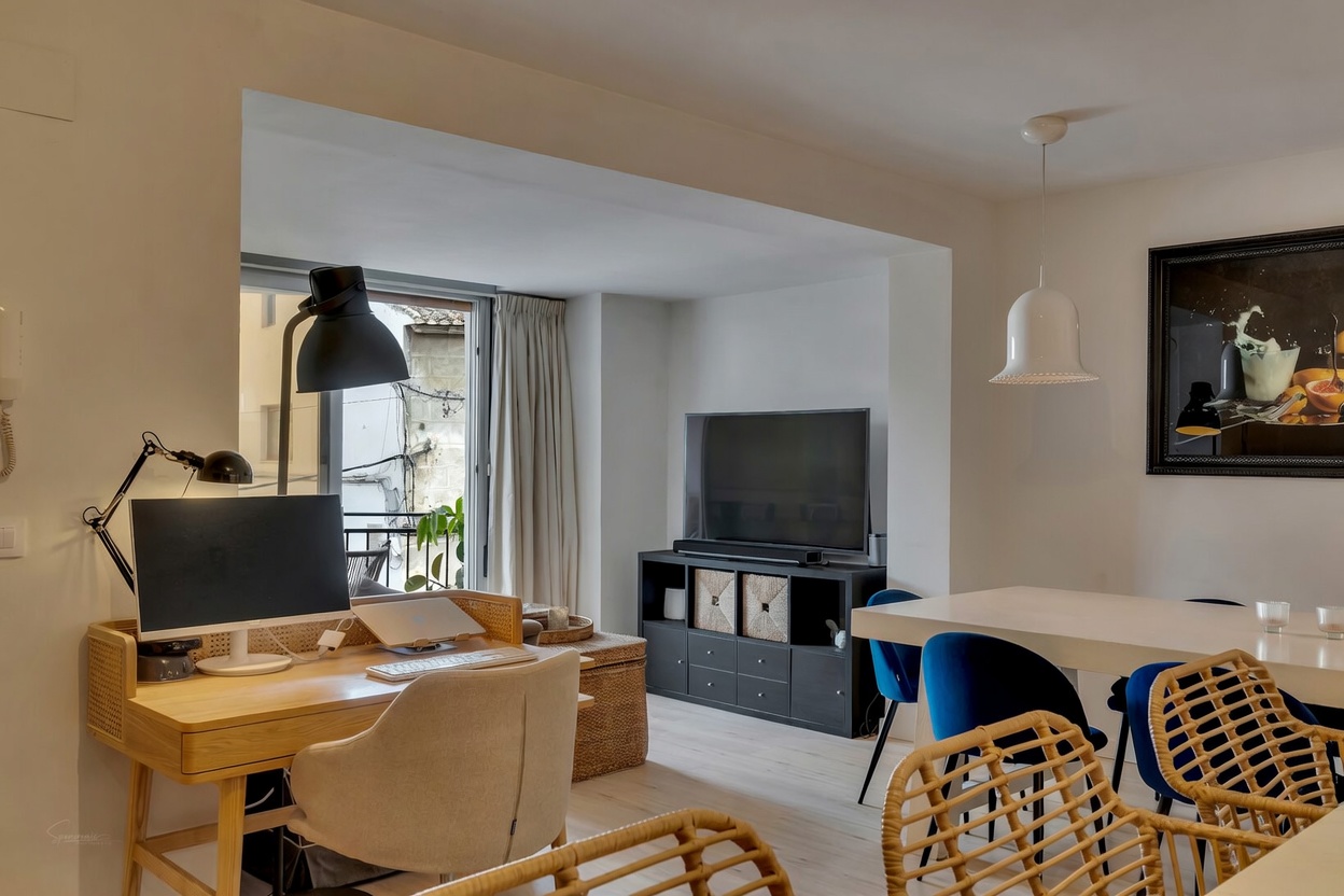 View of the living-dining area with light wood desk and balcony access in Jávea.
