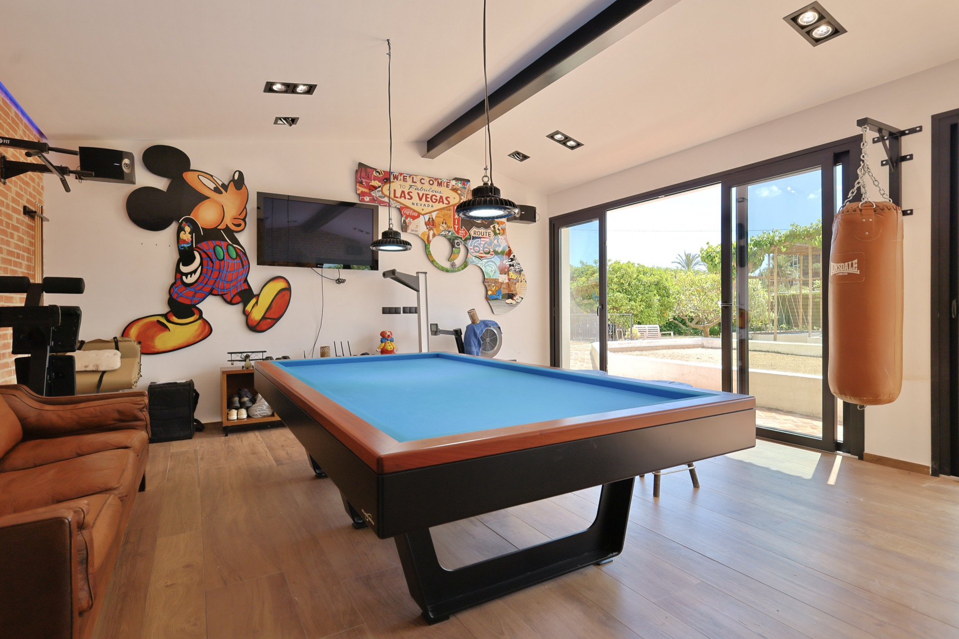 Games room with a blue pool table and themed decoration, includes a punching bag and garden access.