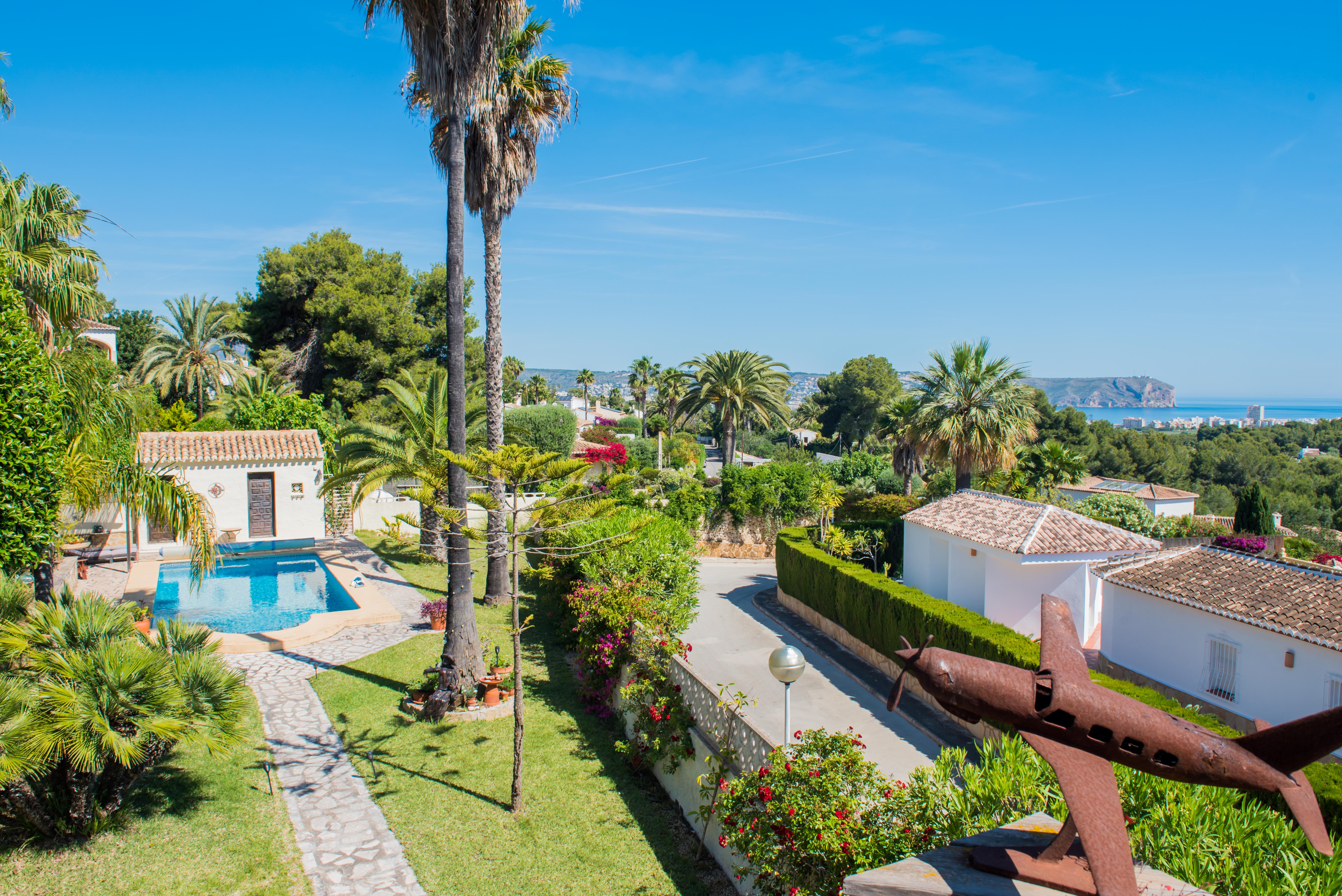 Elevated view of the Mediterranean garden with pool and rusted airplane sculpture in Jávea. Elevated view of the Mediterranean garden with pool and rusted airplane sculpture in Jávea.