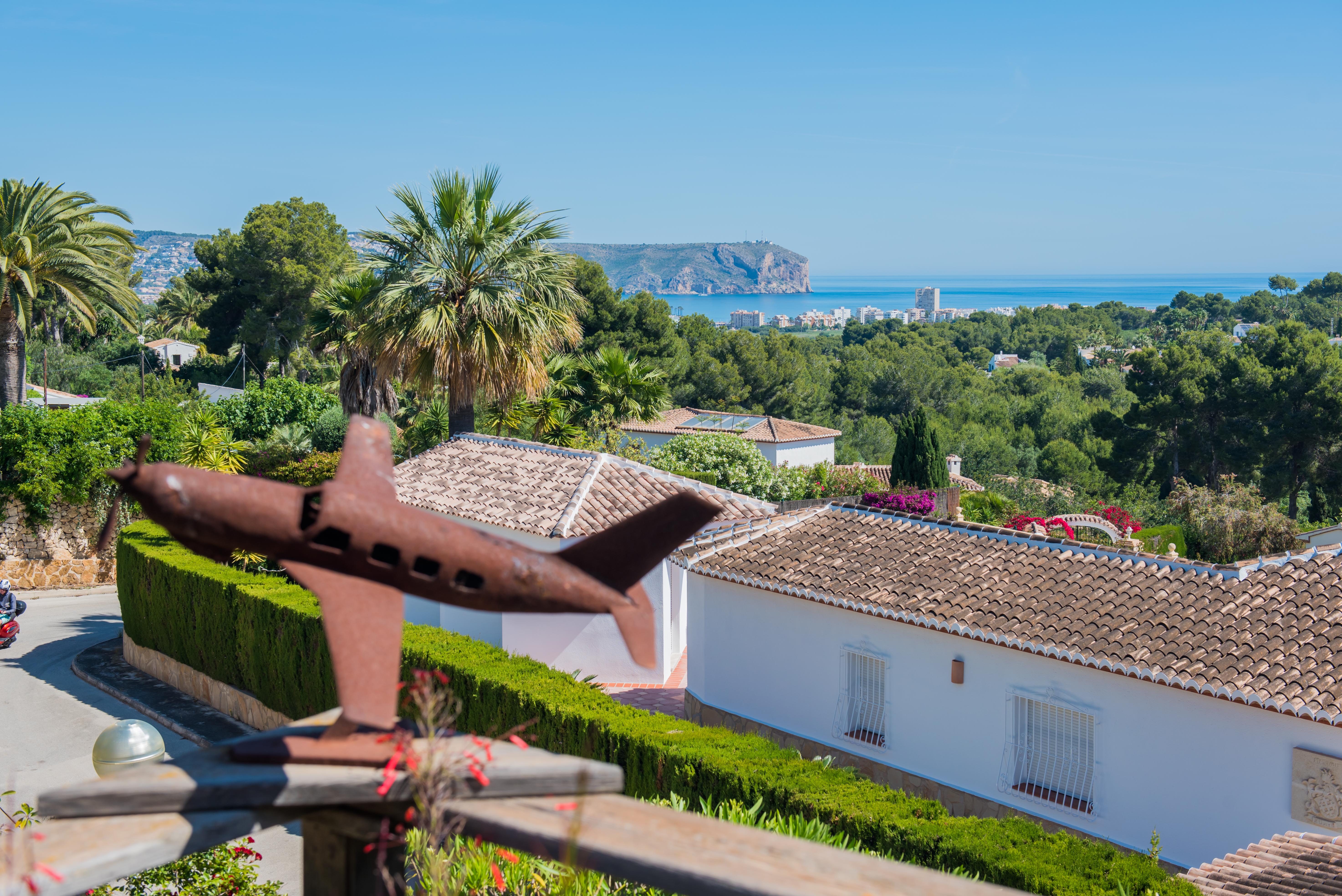 Panoramic view of Jávea from the terrace, featuring an airplane sculpture in the foreground and lush greenery. Panoramic view of Jávea from the terrace, featuring an airplane sculpture in the foreground and lush greenery.