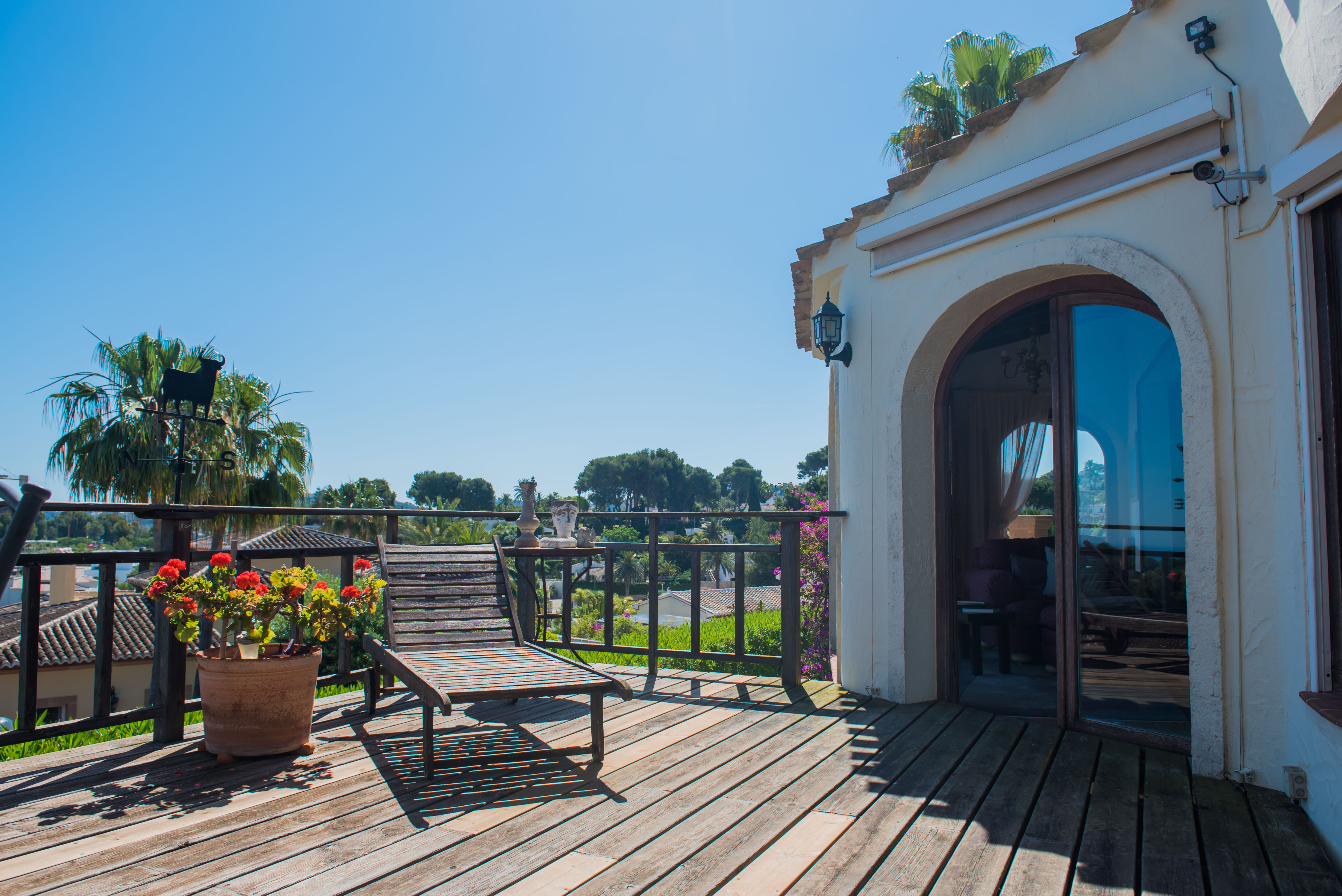 Sunny terrace with wood flooring, a lounge chair, and views of the Mediterranean landscape. Sunny terrace with wood flooring, a lounge chair, and views of the Mediterranean landscape.