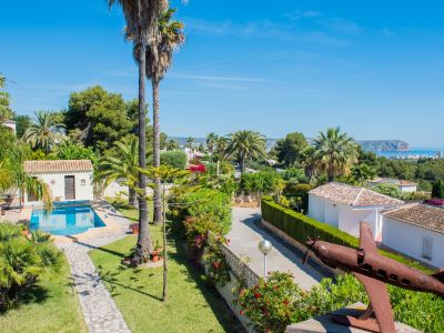 Elevated view of the Mediterranean garden with pool and rusted airplane sculpture in Jávea.