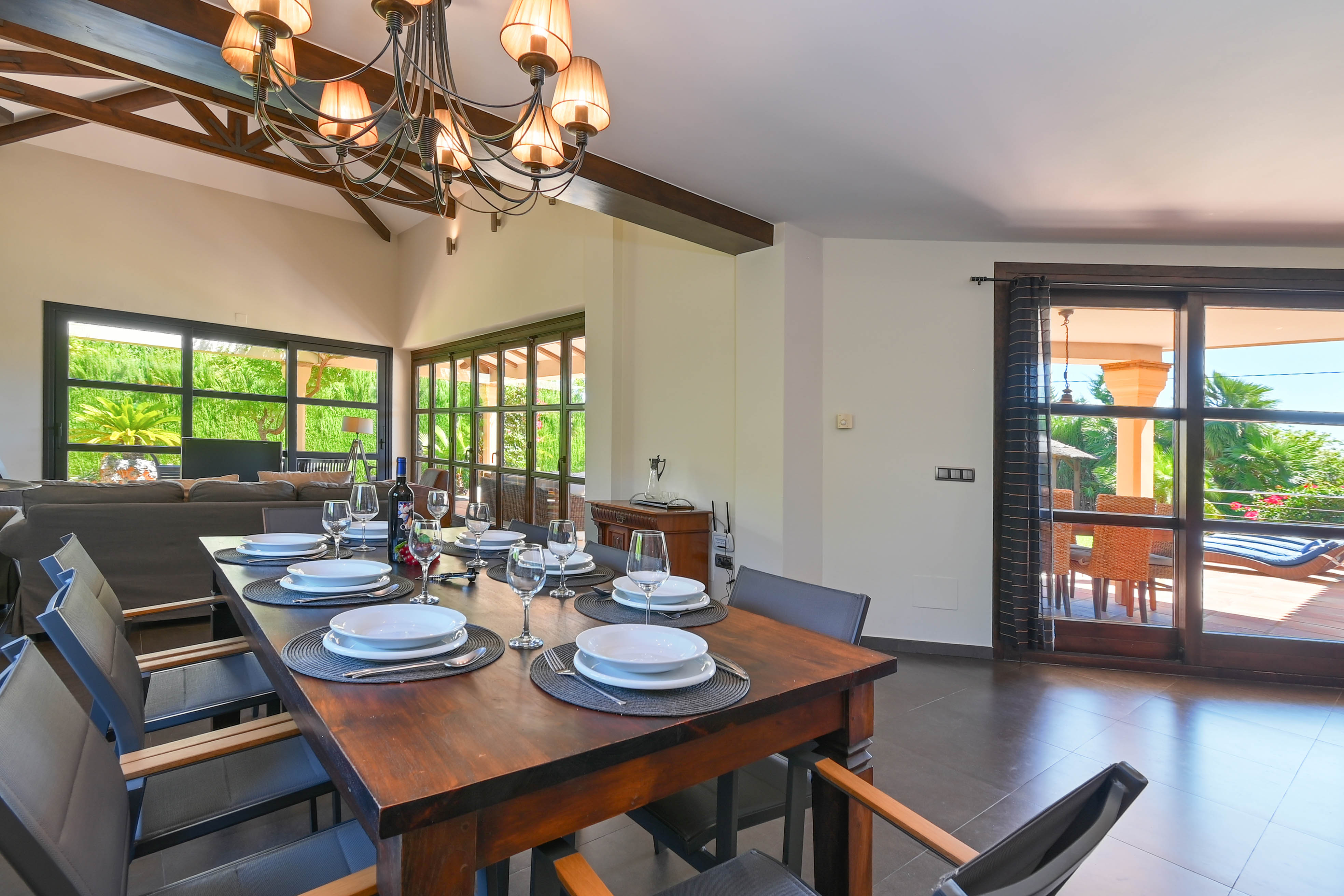 Bright dining room with dark wood table and views to the terrace with pool.