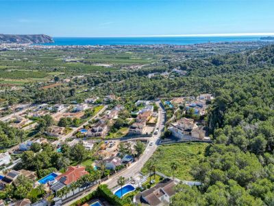Aerial view of the Piver urbanization in Jávea, featuring villas, pools, and Mediterranean vegetation.