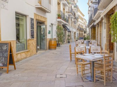 Charming street with outdoor tables, perfect for enjoying local cuisine in Jávea.