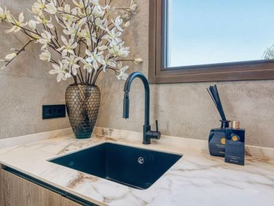 Countertop detail with black sink, modern faucet, and floral decor. Elegance and functionality in the kitchen.