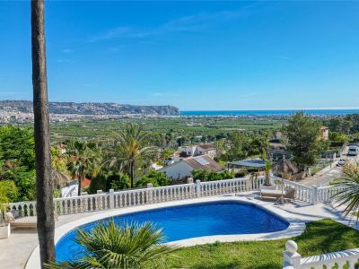 Elevated view of the pool with white railing and panoramic views of the sea and the city.