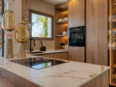 Kitchen detail featuring a veined marble island, light wood cabinetry, and modern appliances.