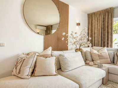 Living room detail with a beige upholstered modular sofa and decorative wooden wall.