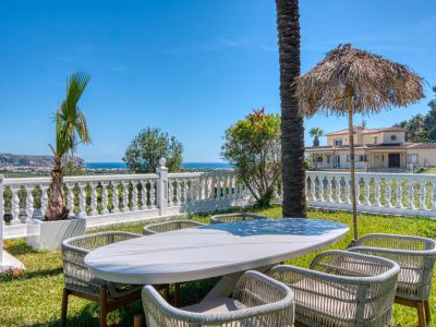 Outdoor dining area with marble table and Mediterranean sea views from the villa's garden.