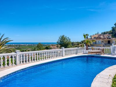 Pool view featuring a white balustrade railing, with views of the Mediterranean Sea and Jávea's landscape.