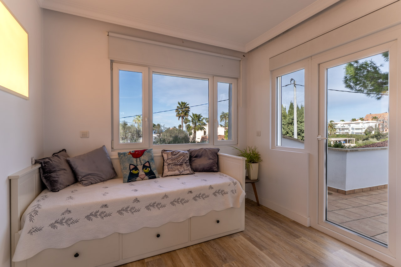 Bright bedroom featuring a daybed, exterior views, and terrace access.