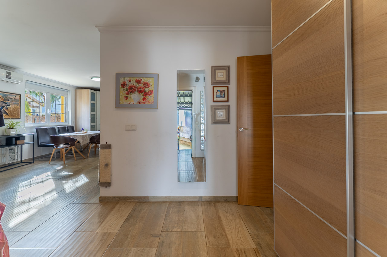 Bright entryway featuring wood-look ceramic tile flooring and wall decor.