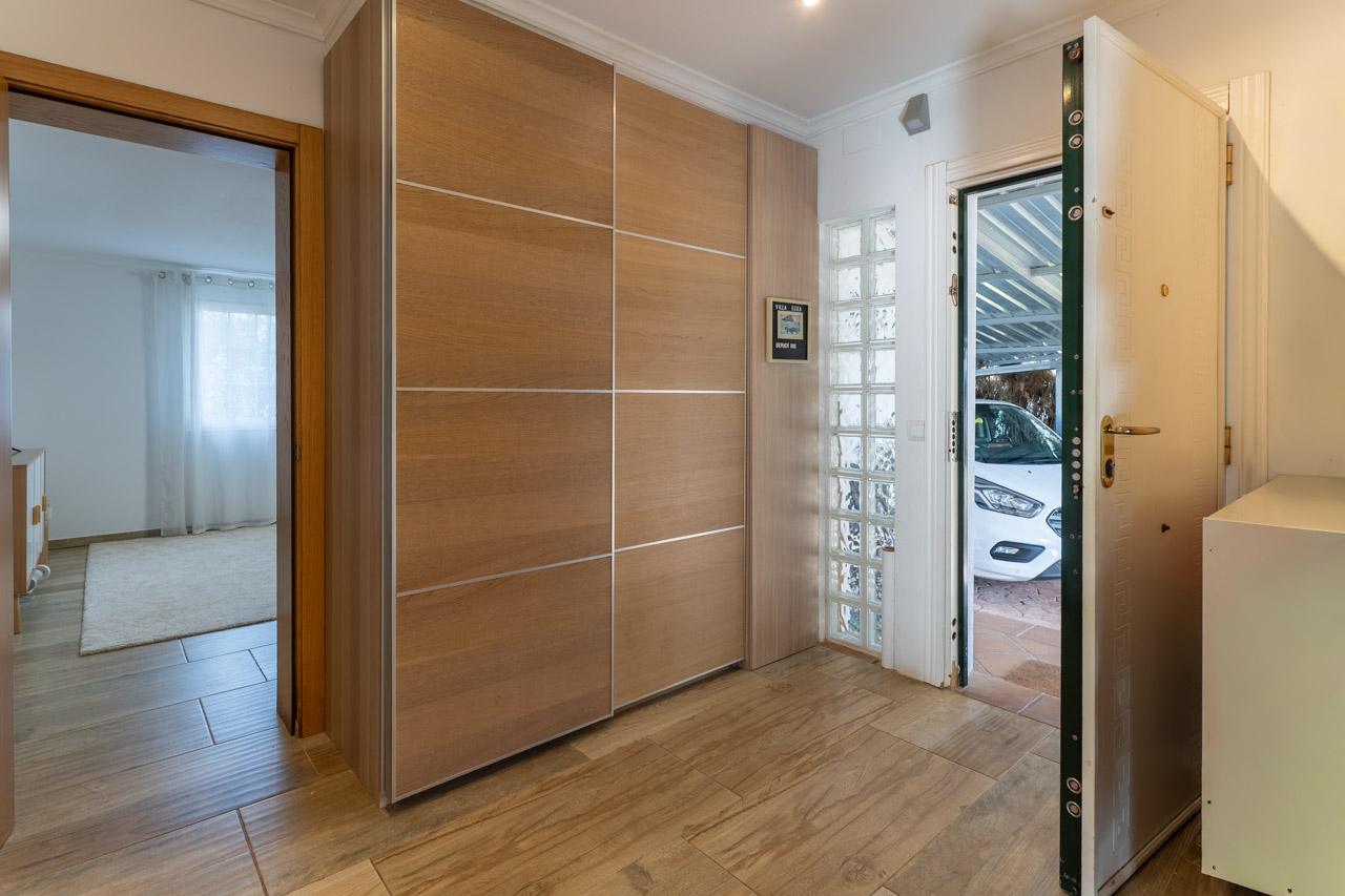 Entryway featuring a light wood built-in wardrobe and a security door open to the garage.