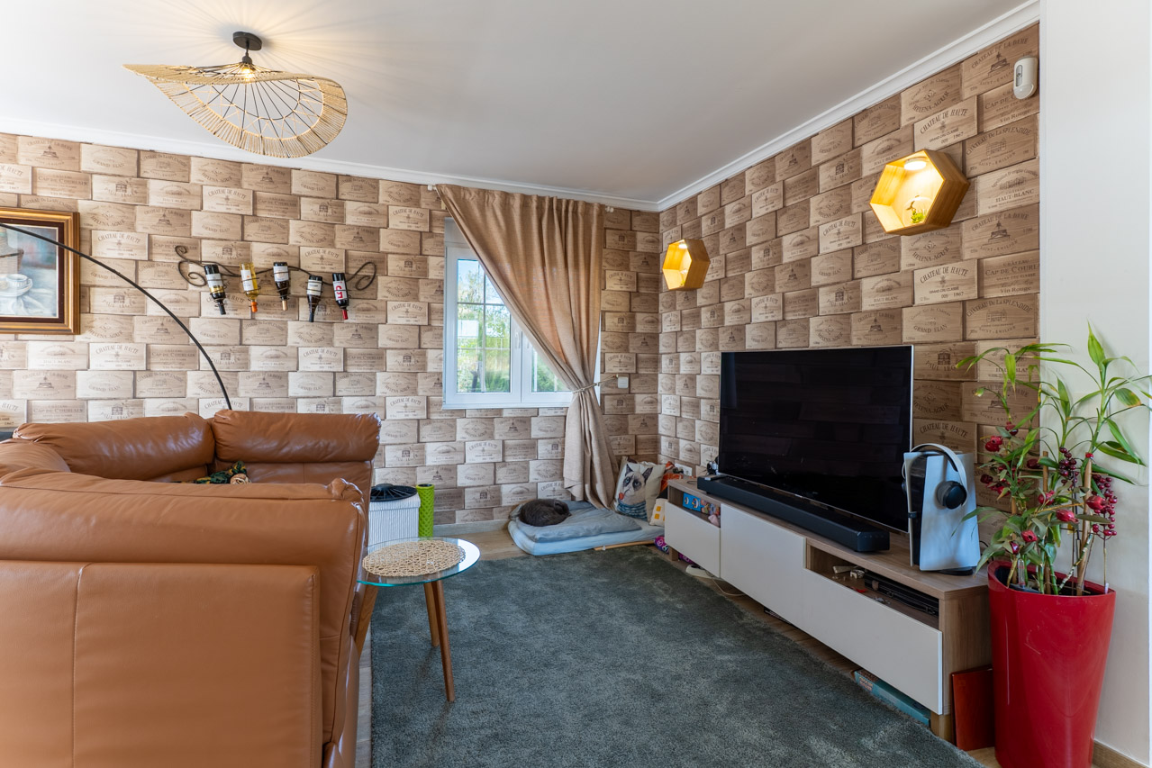 Living room featuring wine box wallpaper and a brown leather sofa.