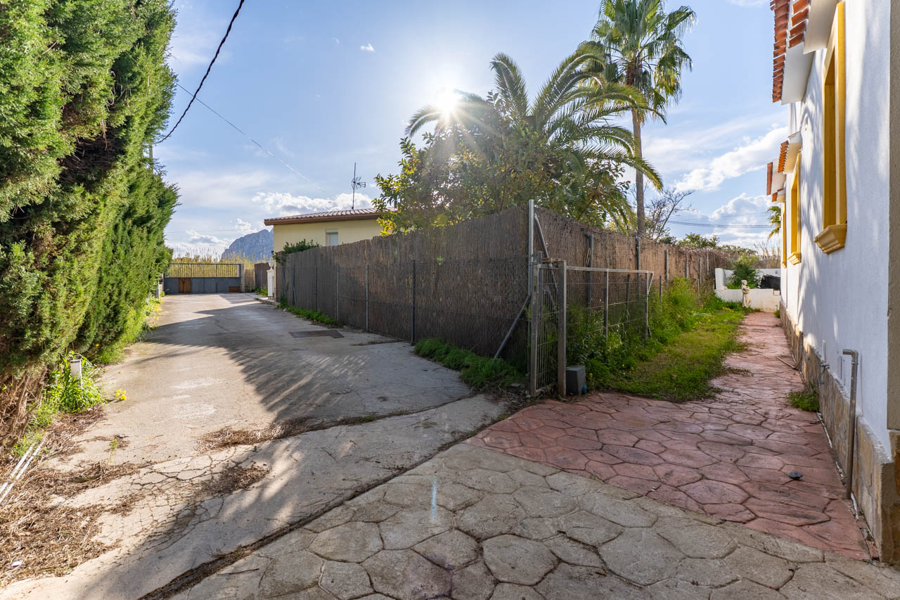 Side access to the property featuring a stone path and bamboo fence.