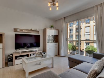 Bright living room featuring modern furniture and balcony access with city views.