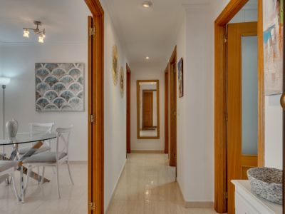 Hallway detail with wooden doors and cream-colored tiled floor. A full-length mirror is visible in the background.